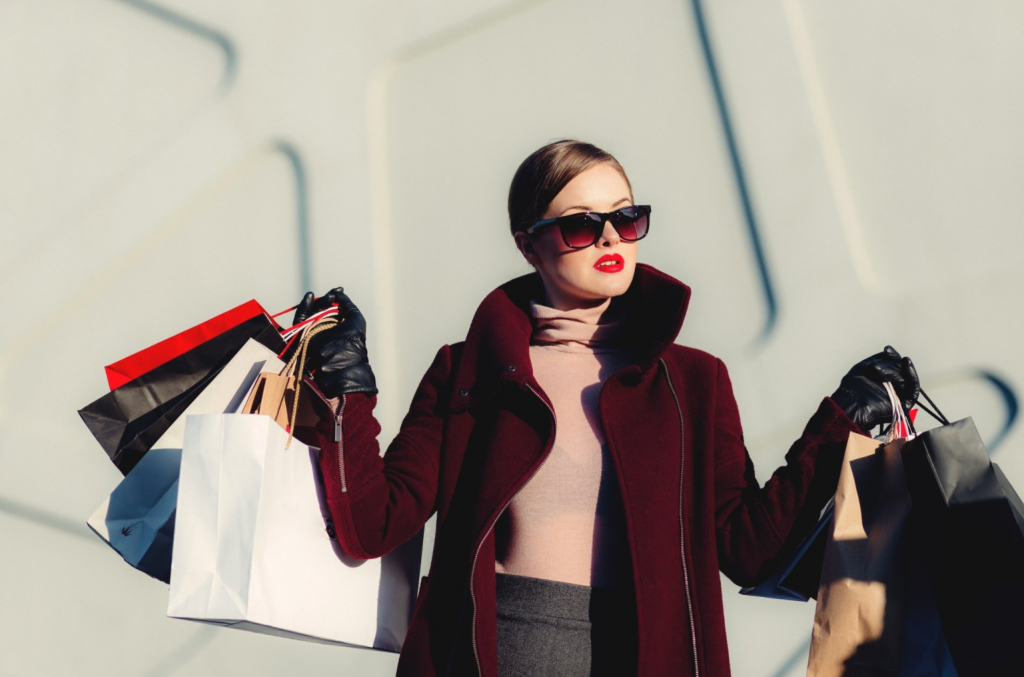 Foto de jovem carregando lotes de sacolas de compras. Os serviços Compre agora, pague depois, estão mudando como, quando e por que os consumidores compram online.
