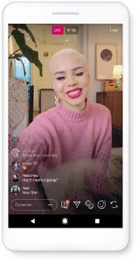 Mujer con suéter rosa filmando IGTV en vivo