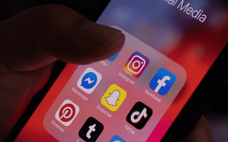 ręka trzymająca telefon z aplikacjami społecznościowymi na ekranie