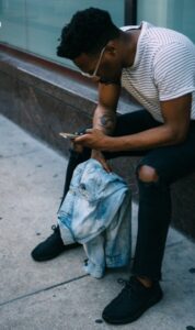 Homme assis tout en utilisant un smartphone