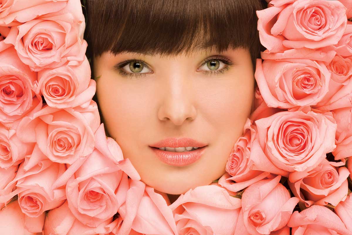 visage de femme entouré de roses couleur saumon.
