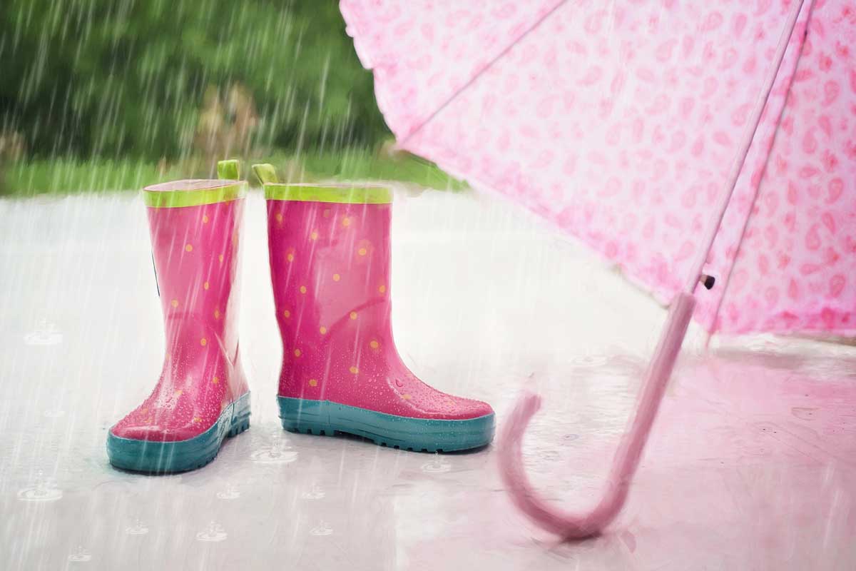 bottes de pluie roses et parapluie dans les averses d'avril.