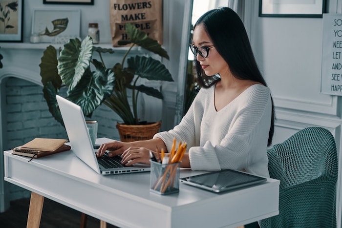 Femeie care stă la un laptop