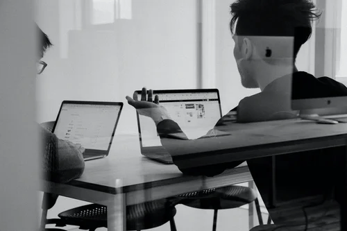zwei Personen vor einem Laptop
