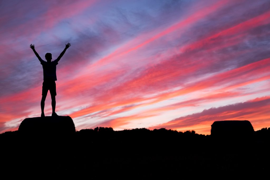 Qualcuno in piedi sulla cima di una montagna - Argomenti per blog motivazionali - Blog di Copify