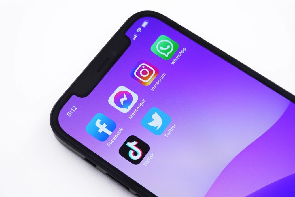 iPhone avec fond violet et diverses applications de médias sociaux