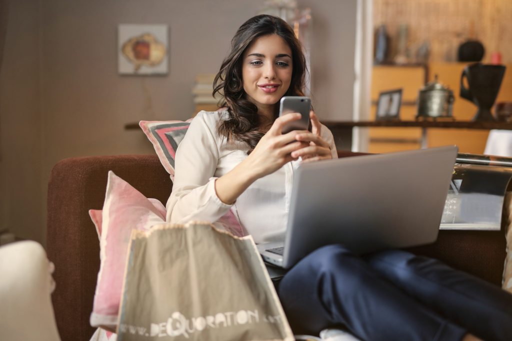 Uma mulher fazendo compras em um smartphone - Como construir uma campanha de Natal de comércio eletrônico - Copify blog