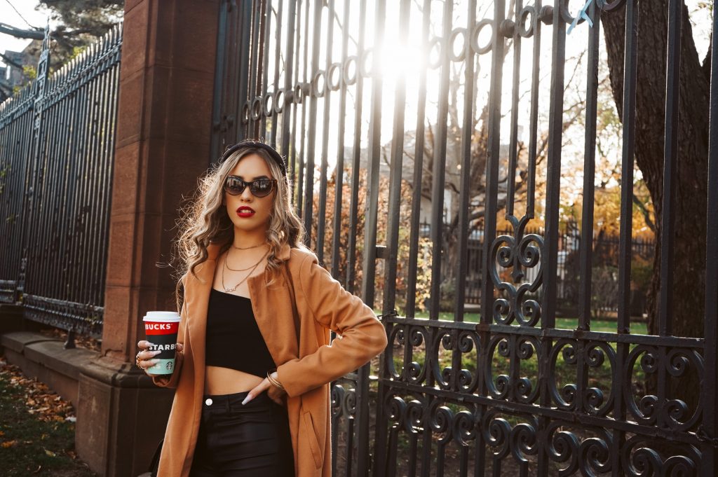 Influencer care pozează la porți cu cana Starbucks - Cum să crești notorietatea mărcii tale - Copify blog