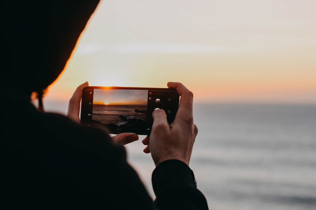 Quelqu'un prenant une photo d'un coucher de soleil - Comment mettre à jour le contenu d'un site Web pour le référencement