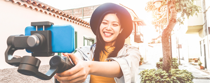 Kobieta trzymająca telefon na kij do selfie