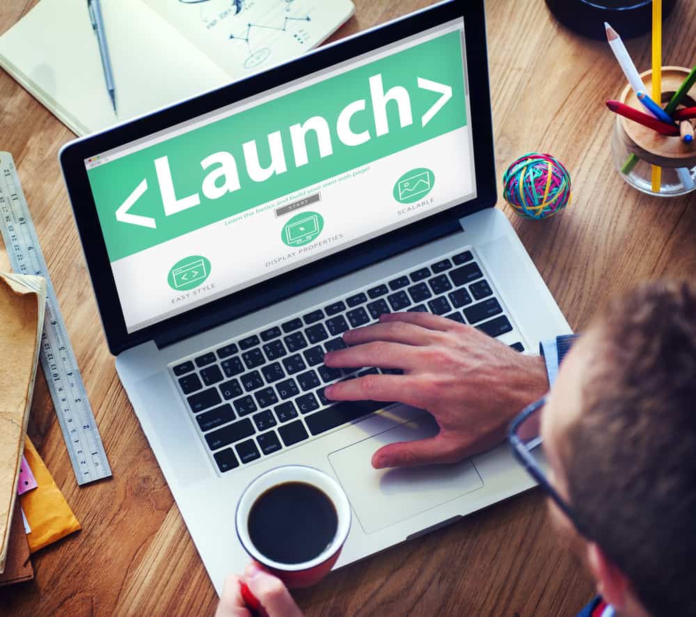 Homme lançant un nouveau blog sur un ordinateur portable