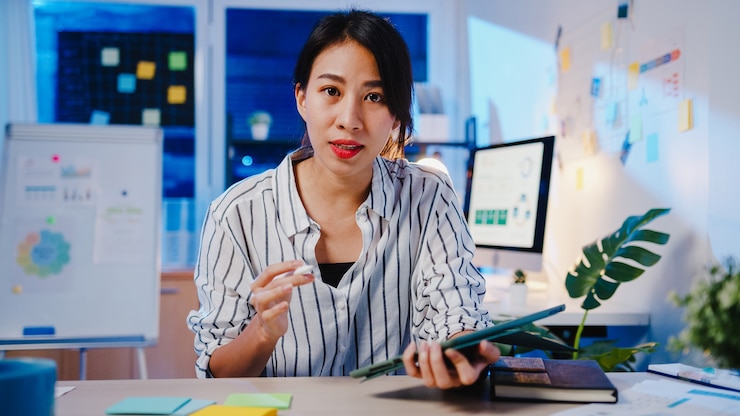asie-businesswoman-social-distancing-new-normal-virus-prevention-looking-camera-presentation-collegue-about-plan-video-call-while-work-office-night_7861-3198