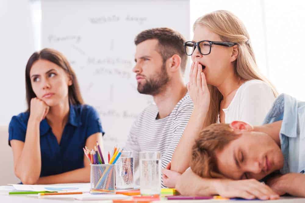 Un gruppo di persone annoiate in cui uno sbadiglia e l'altro dorme.