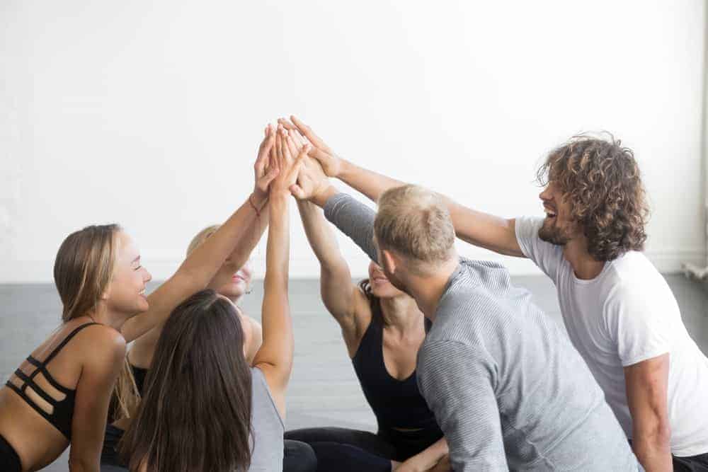 Un gruppo di amici che dà il cinque in segno di lavoro di squadra.