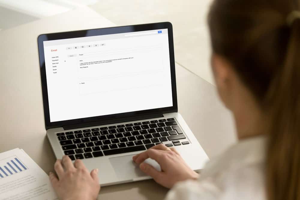 O femeie de afaceri tastând un e-mail pe un laptop.