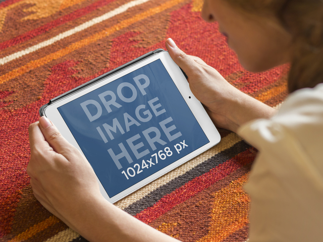 Maquette de fille à l'aide d'un iPad blanc allongé sur l'image de la scène Placeit Tapis