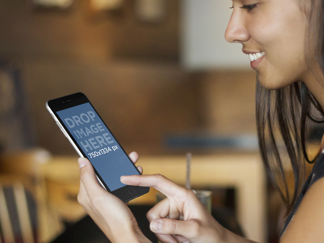 Jeune femme utilisant un iPhone au modèle de maquette de restaurant Placeit Image de scène