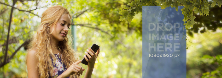 Belle maquette de fille blonde à l'aide de son smartphone sous une image de scène Placeit arbre