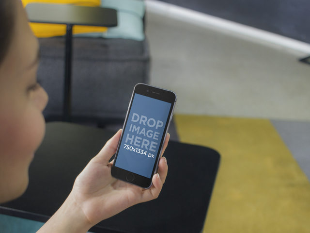 iPhone Mockup eines Mädchens, das ein schwarzes iPhone 6 im Colorful Lounge Placeit Stage Image verwendet
