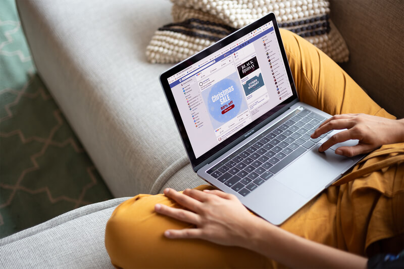 Mulher trabalhando com uma maquete de Macbook sentada em um sofá