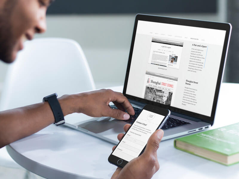 شاب يعمل على حاسوبه المحمول Macbook Pro و Iphone Mockup