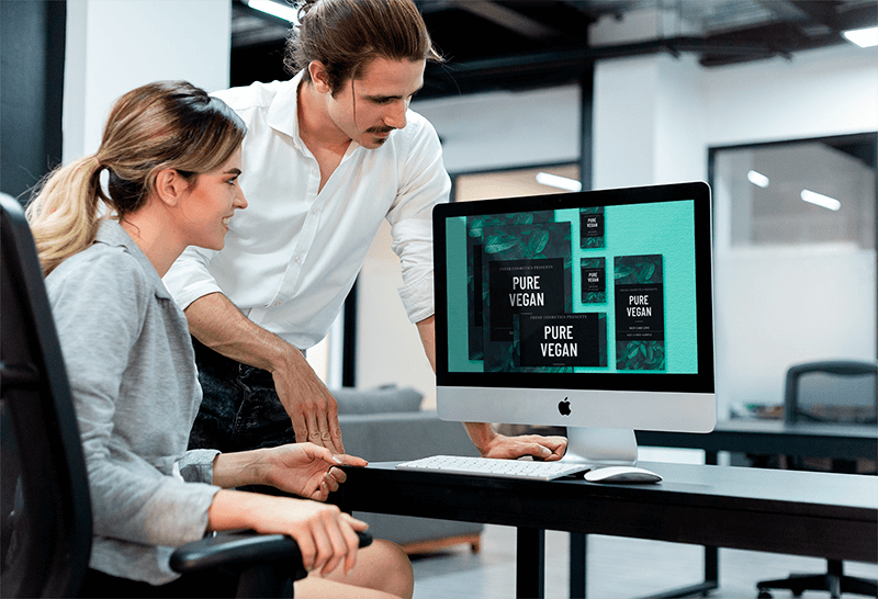 Bir Imac Mockup Üzerinde Çalışan Bir İş Arkadaşına Koçluk Yapan Adam