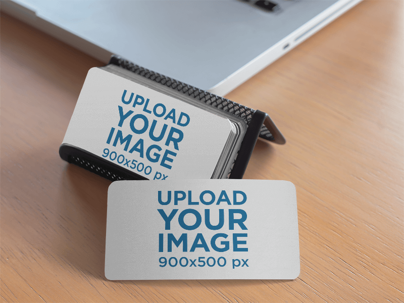 Porte-cartes de visite assis à côté d'une maquette de Macbook Pro