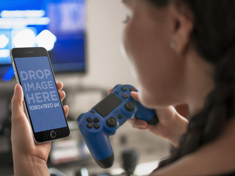 امرأة تلعب PlayStation 4 أثناء النظر إلى نموذج iPhone 6 Mockup