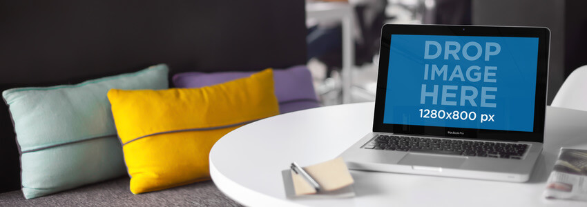 Maquette pour ordinateur portable d'un Macbook assis sur une table à côté d'un canapé