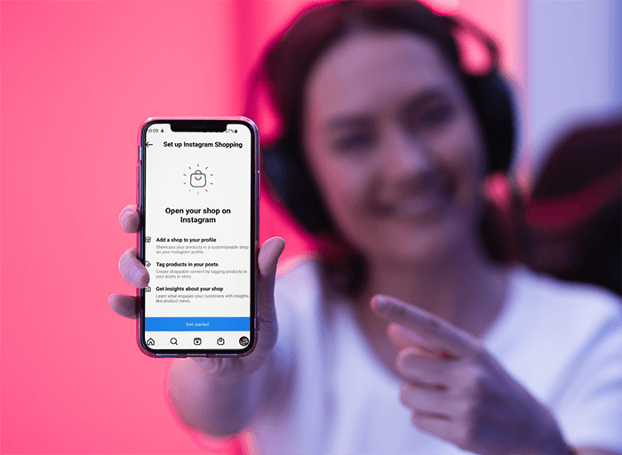 カメラにiPhoneを見せている女性ゲーマーのモックアップ