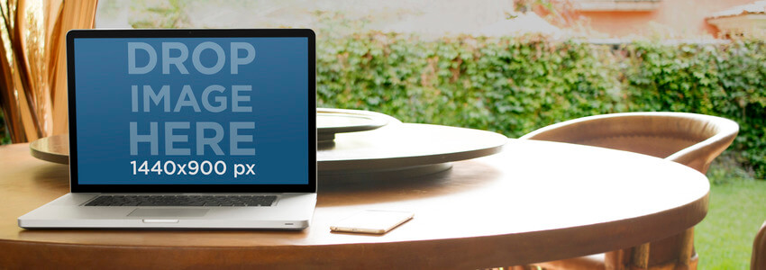 Mockup แล็ปท็อปที่มี MacBook เหนือโต๊ะอาหารในสวน