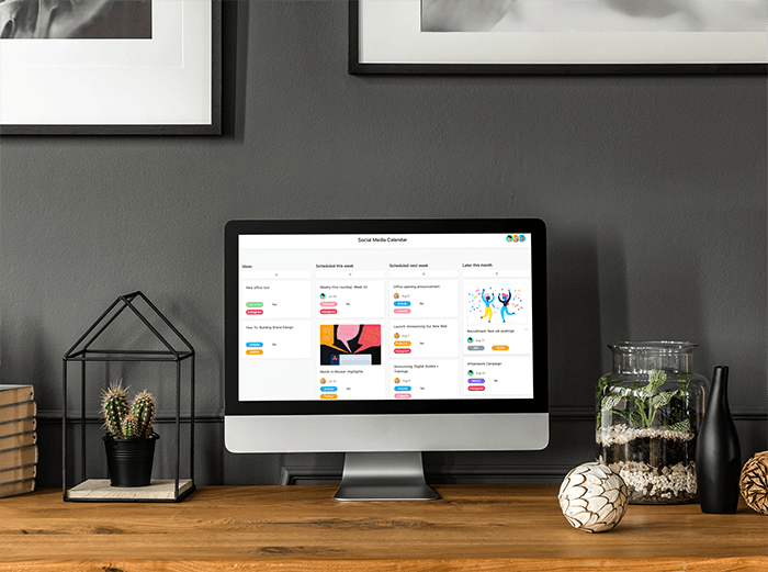 نموذج بالحجم الطبيعي من Imac يتم وضعه على مكتب خشبي بواسطة نباتات داخلية