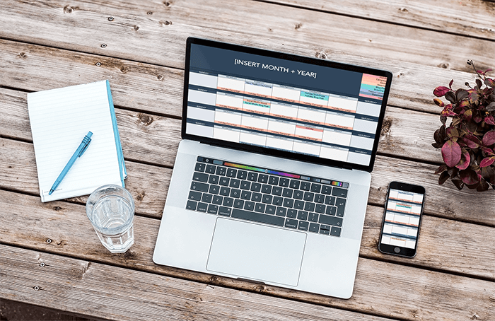 نموذج بالحجم الطبيعي لجهاز Macbook Pro مقاس 15 بوصة وآيفون فوق طاولة خشبية