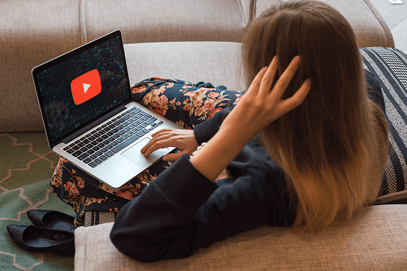 一個在沙發上工作的女人的 Macbook 模型
