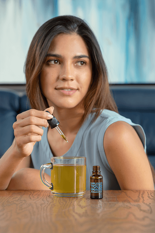 نموذج قطارة لامرأة شابة تضيف زيت Cbd إلى شايها