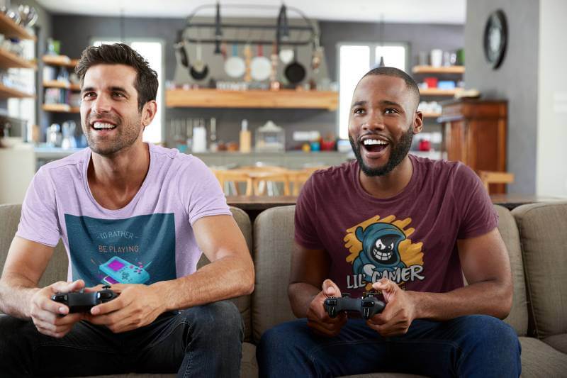 自宅でビデオ ゲームをプレイする 2 人の男性の T シャツ モックアップ
