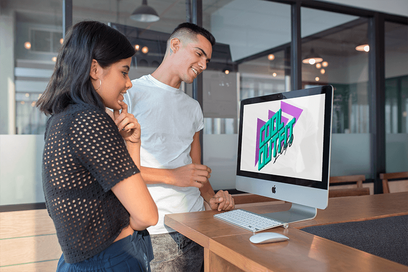 現代のオフィスで Imac のモックアップを見ている男女