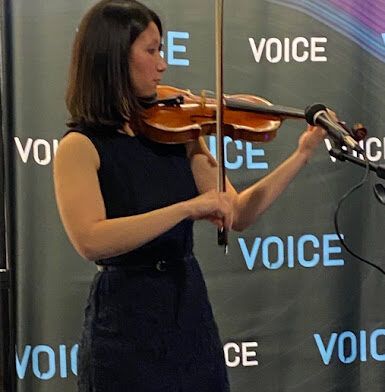 Эмили Банцхаф играет на классической скрипке в выставочном зале Voice22.