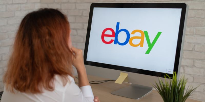コンピューターのモニターで Ebay のロゴを見ている女性