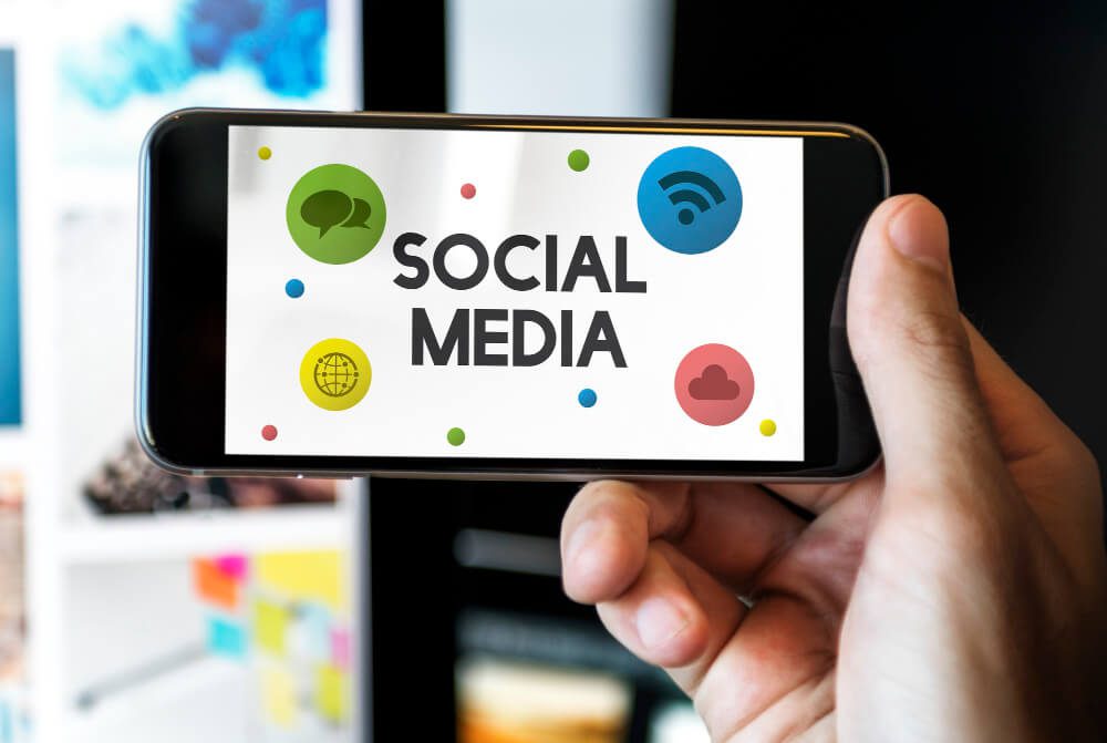 Entregando segurando um telefone celular com ícones e símbolos de mídia social