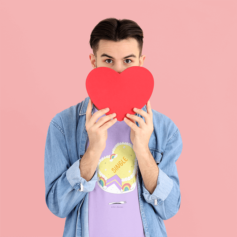 Maquete de camiseta com um homem segurando uma caixa em forma de coração para o dia dos namorados