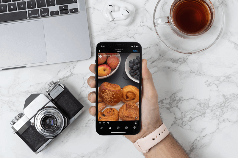 Макет фотографа, держащего Iphone 12 Pro Max над своим столом