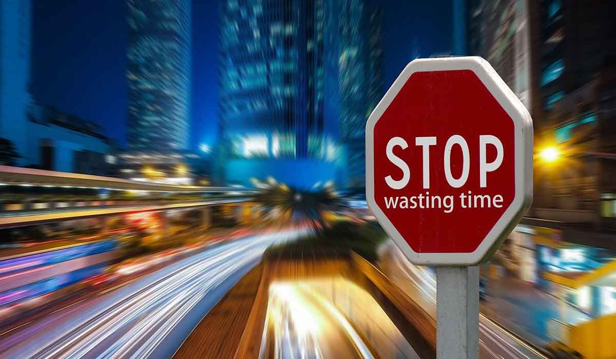 rayas de semáforos con señal de stop roja y edificios azules por la noche.