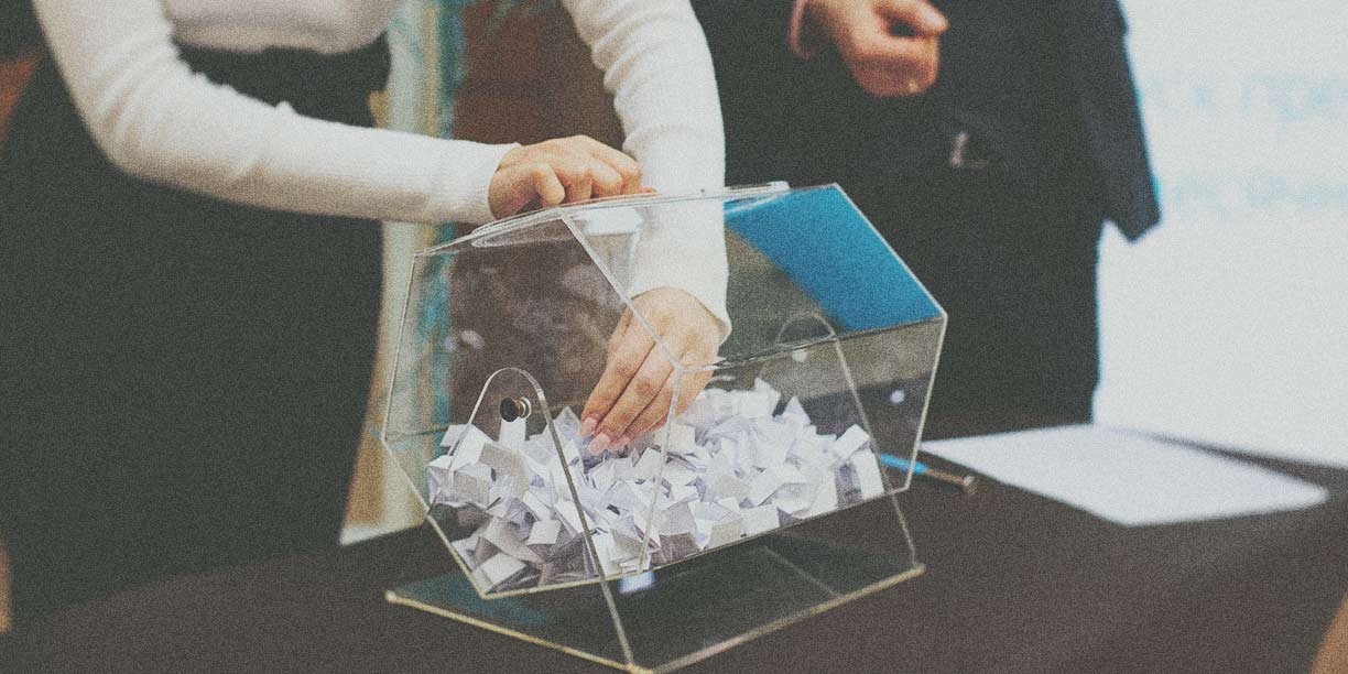 Osoba sięgająca do koszyka loterii, aby wybrać zwycięski los