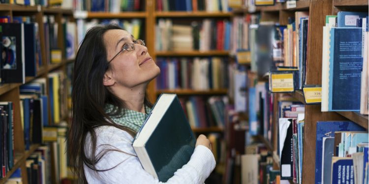 bibliothécaire regardant une étagère