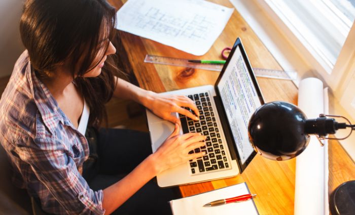 femme tapant sur un ordinateur en tant qu'assistante virtuelle