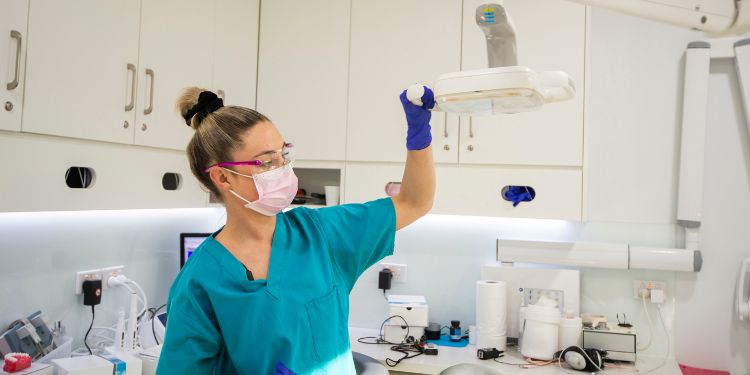 Hygiéniste dentaire tenant une lumière dans un cabinet de dentiste