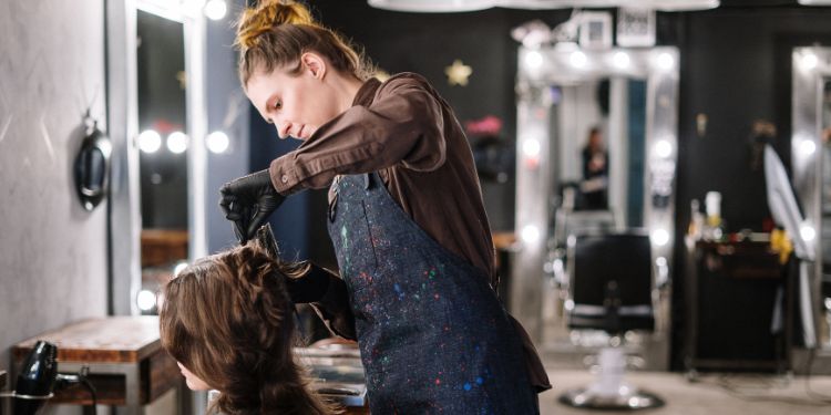 coiffeur coupe les cheveux d'une femme