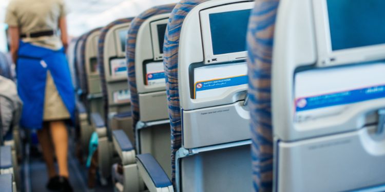 hôtesse de l'air marchant dans l'allée de l'avion