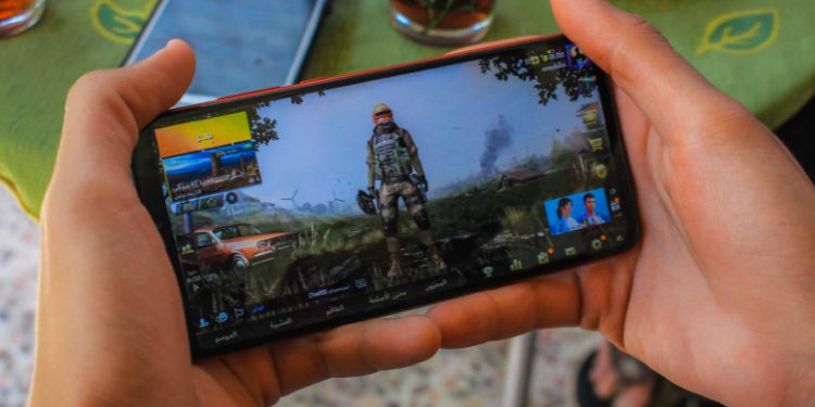 adolescent jouant à des jeux vidéo sur smartphone